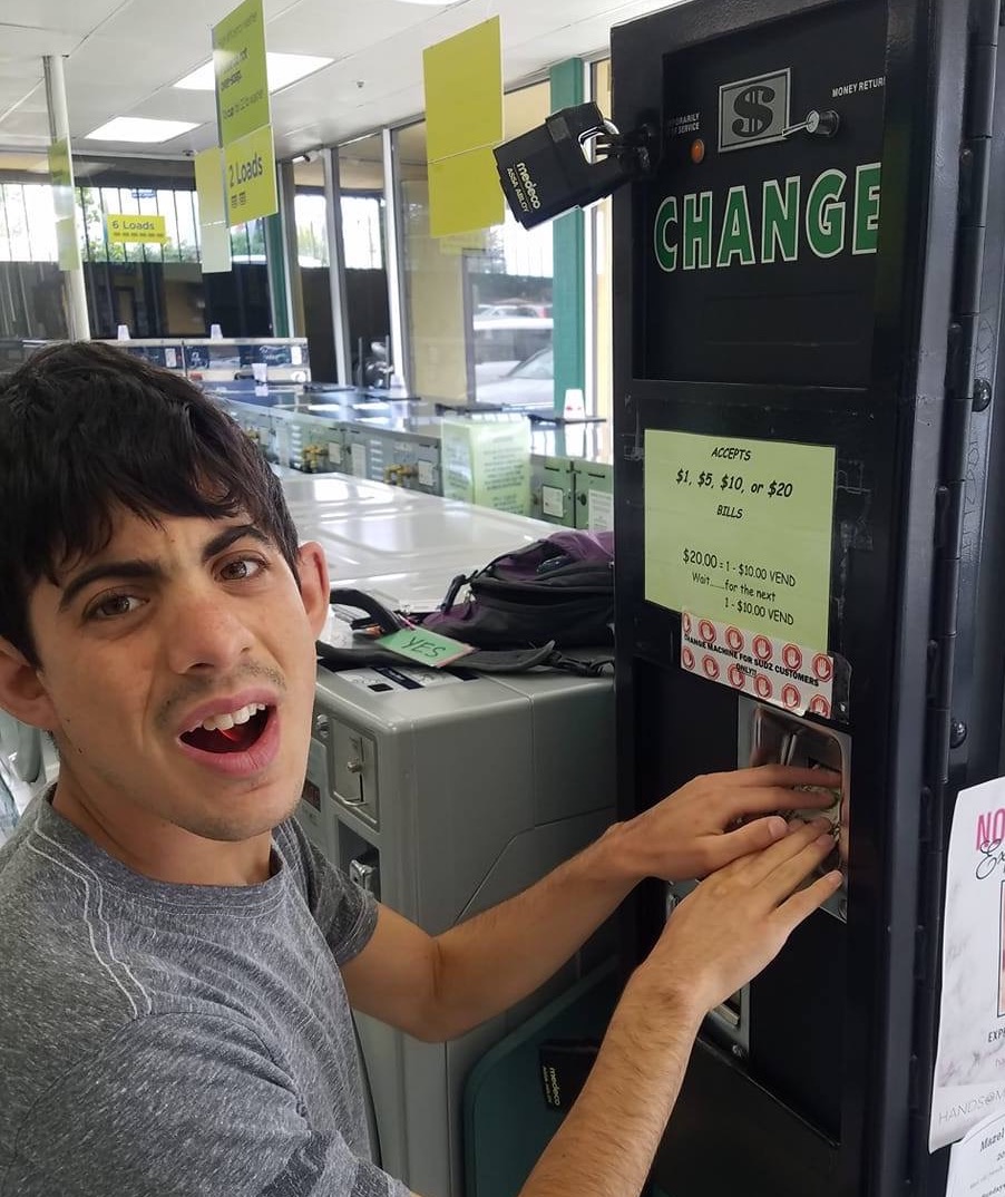 A student getting change from a laundromat machine