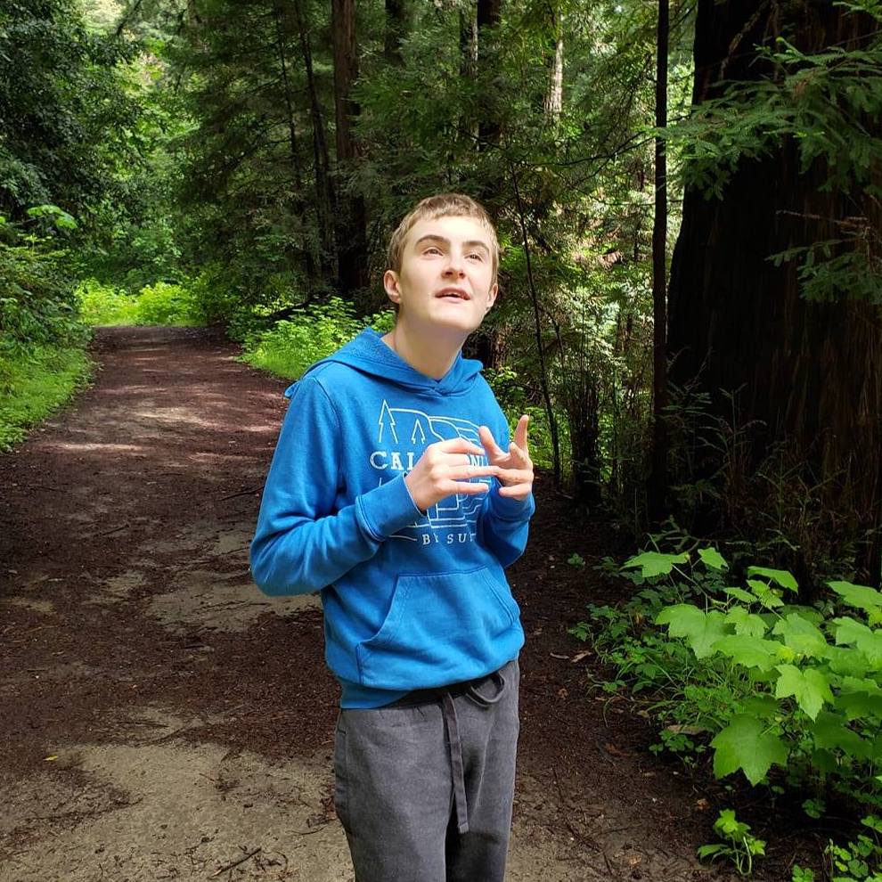 A student stimming happily on a forest trail